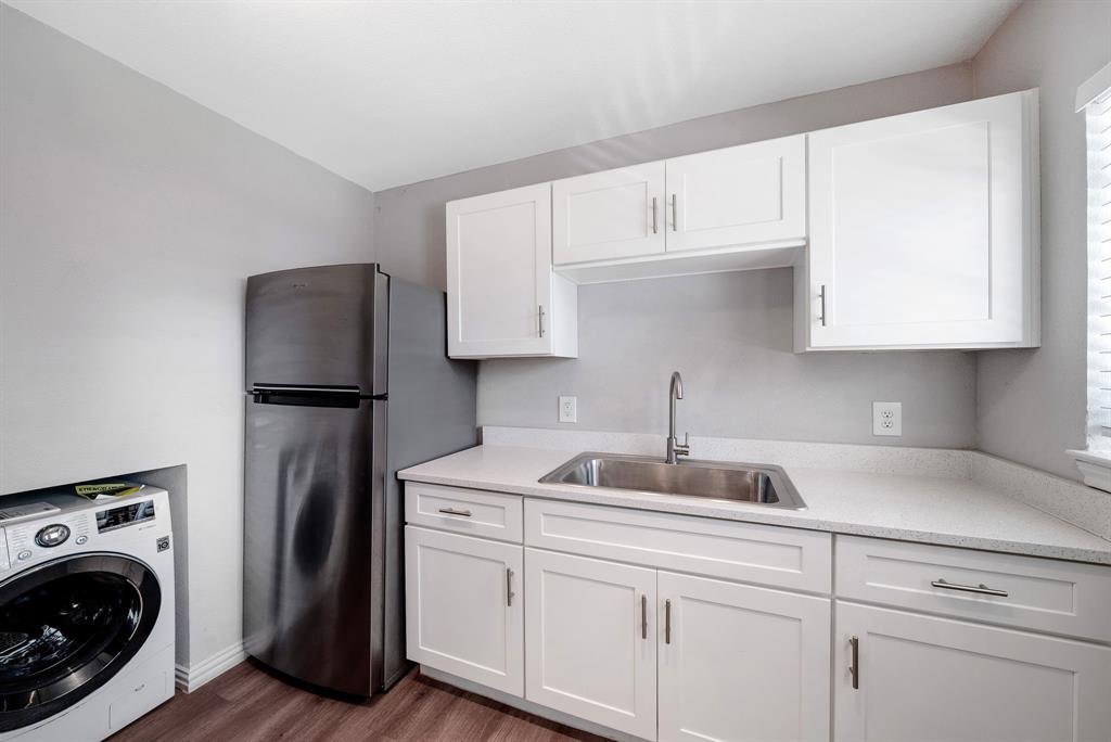 a kitchen with stainless steel appliances granite countertop a sink a refrigerator and cabinets