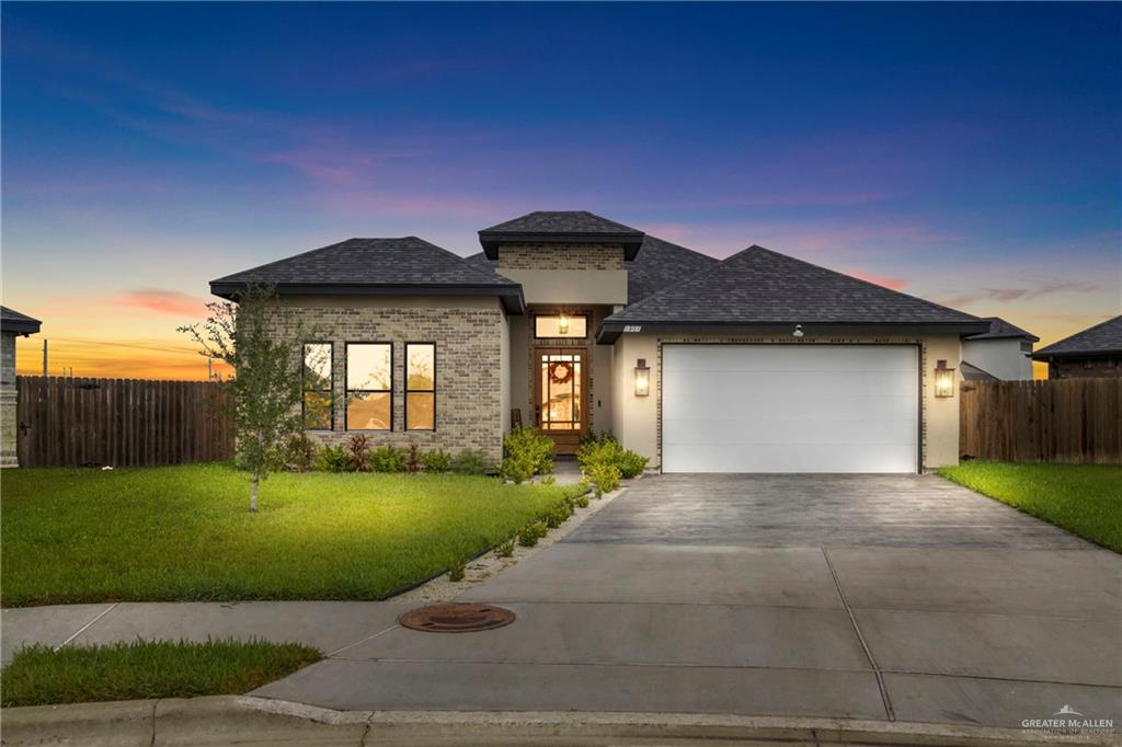 Prairie-style home with a garage and a yard