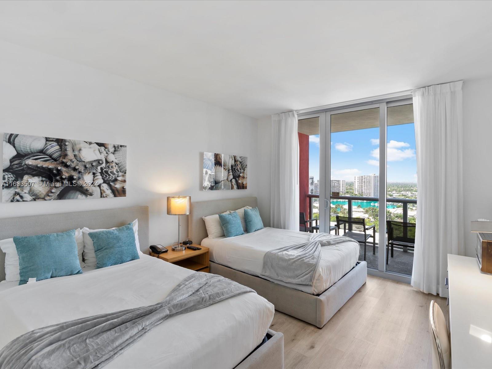 a bedroom with two beds and large window