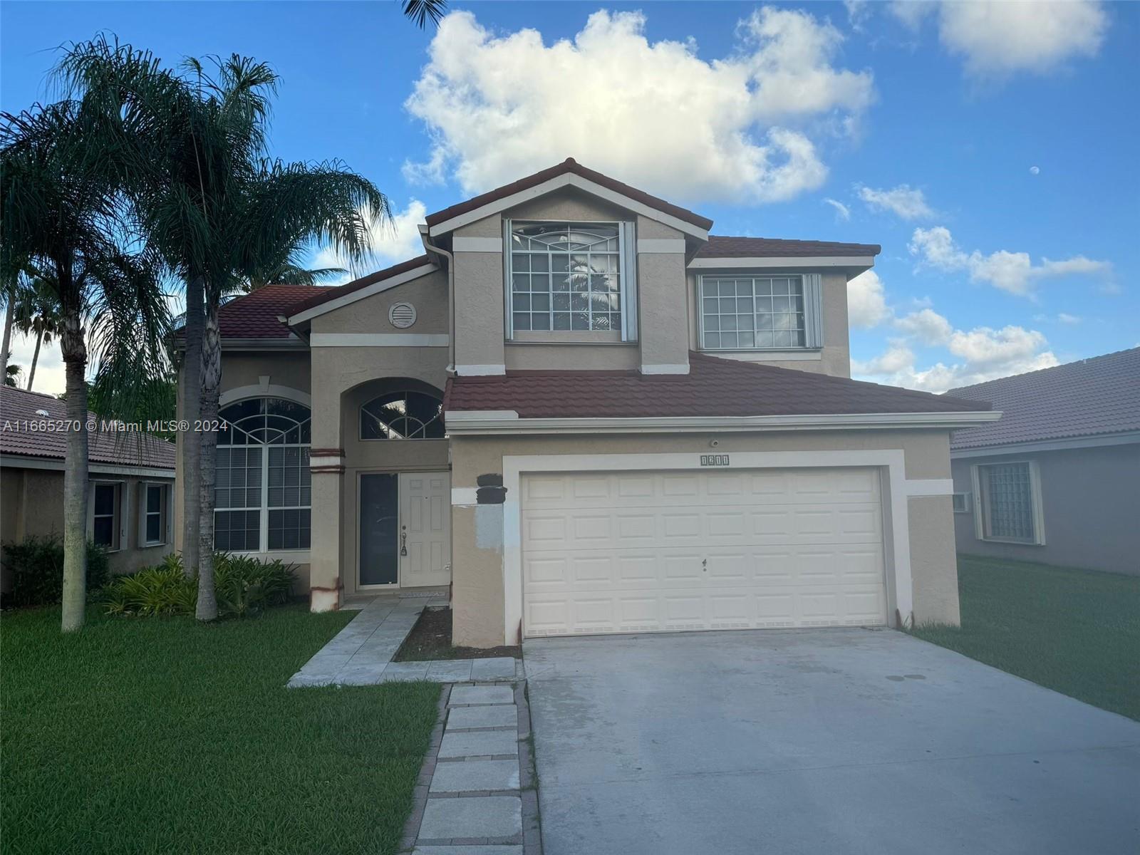 a front view of a house with a yard and garage