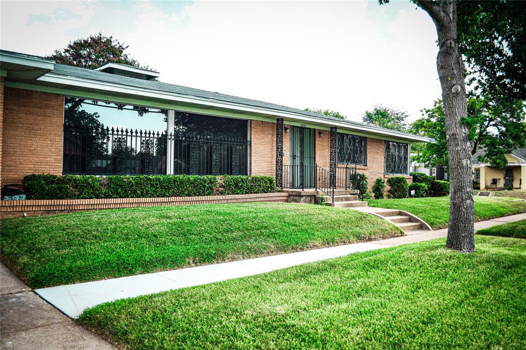 a front view of a house with a yard and potted plants