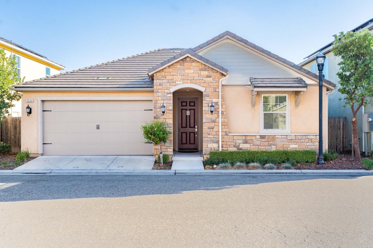 a front view of a house with a yard and garage