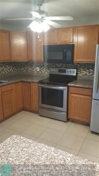 a kitchen with stainless steel appliances granite countertop a sink and a stove