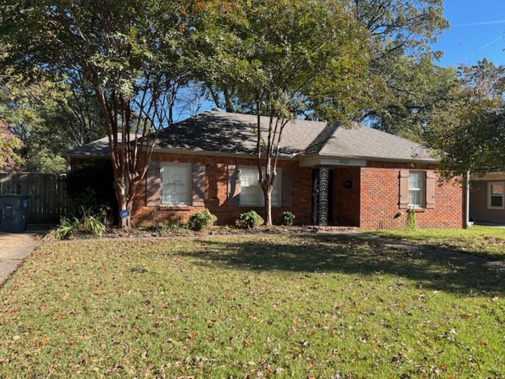 Ranch-style home featuring a front lawn