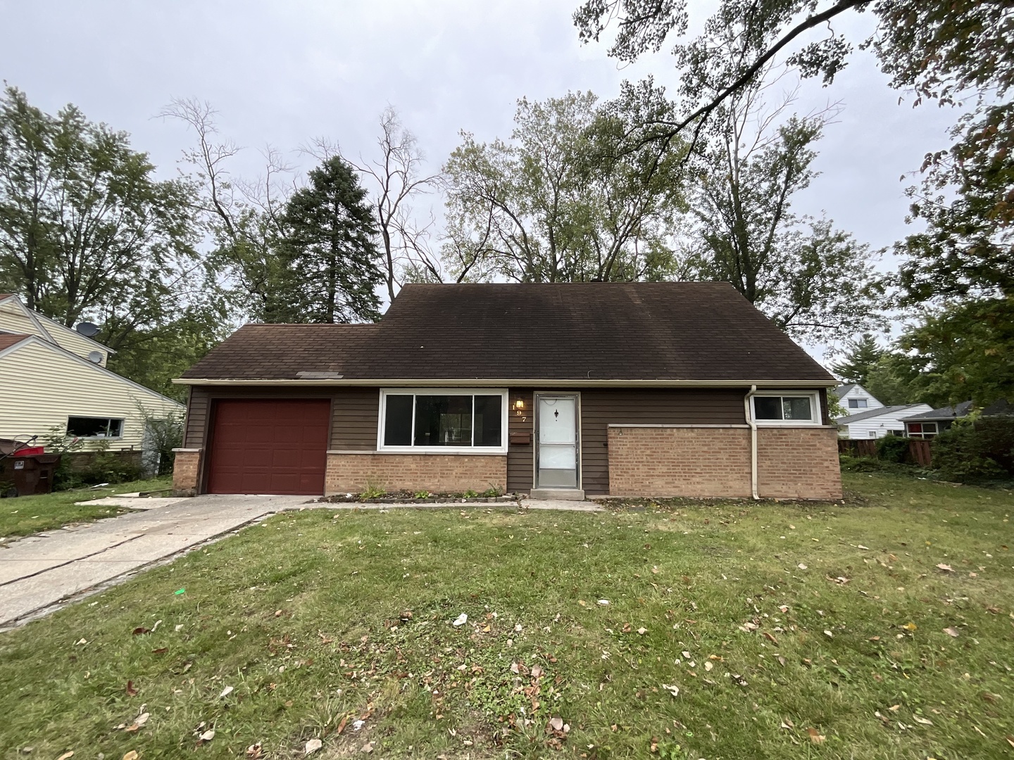 a front view of house with yard and trees all around