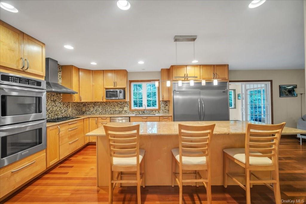 a kitchen with stainless steel appliances granite countertop a stove top oven a sink dishwasher and a refrigerator