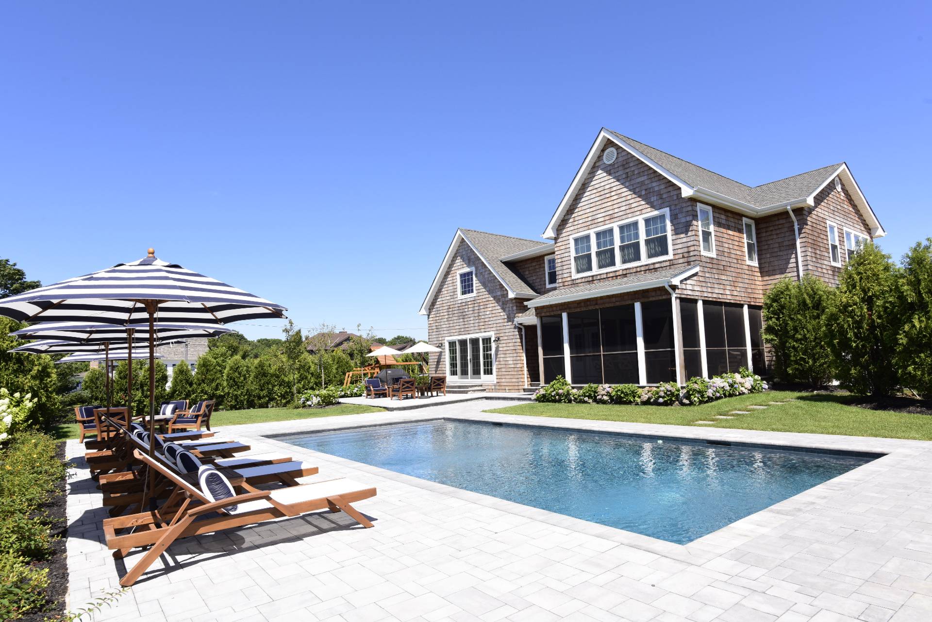 a view of a house with pool and chairs