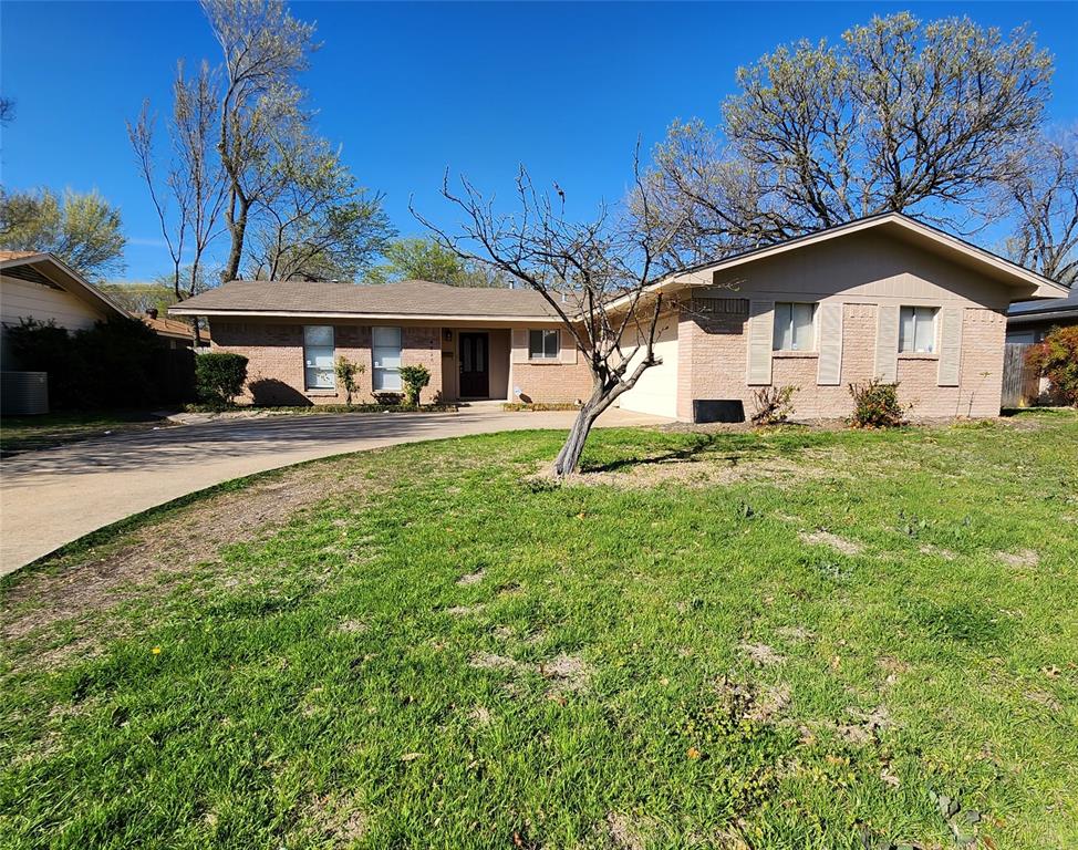 a house that has a big yard next to a road