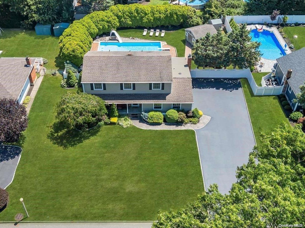 an aerial view of a house with a yard basket ball court and outdoor seating