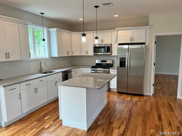 a kitchen with stainless steel appliances a refrigerator sink and wooden floor