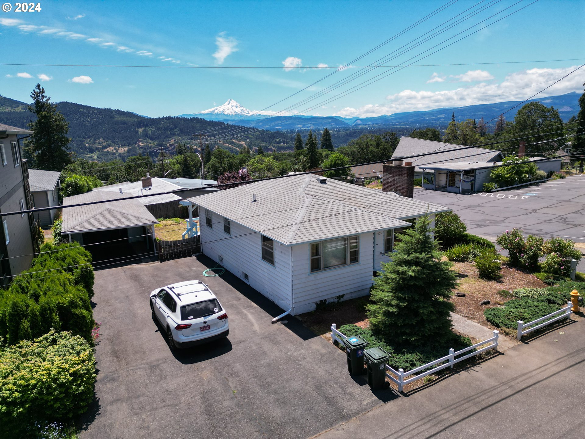 an aerial view of a house with a garden and mountain