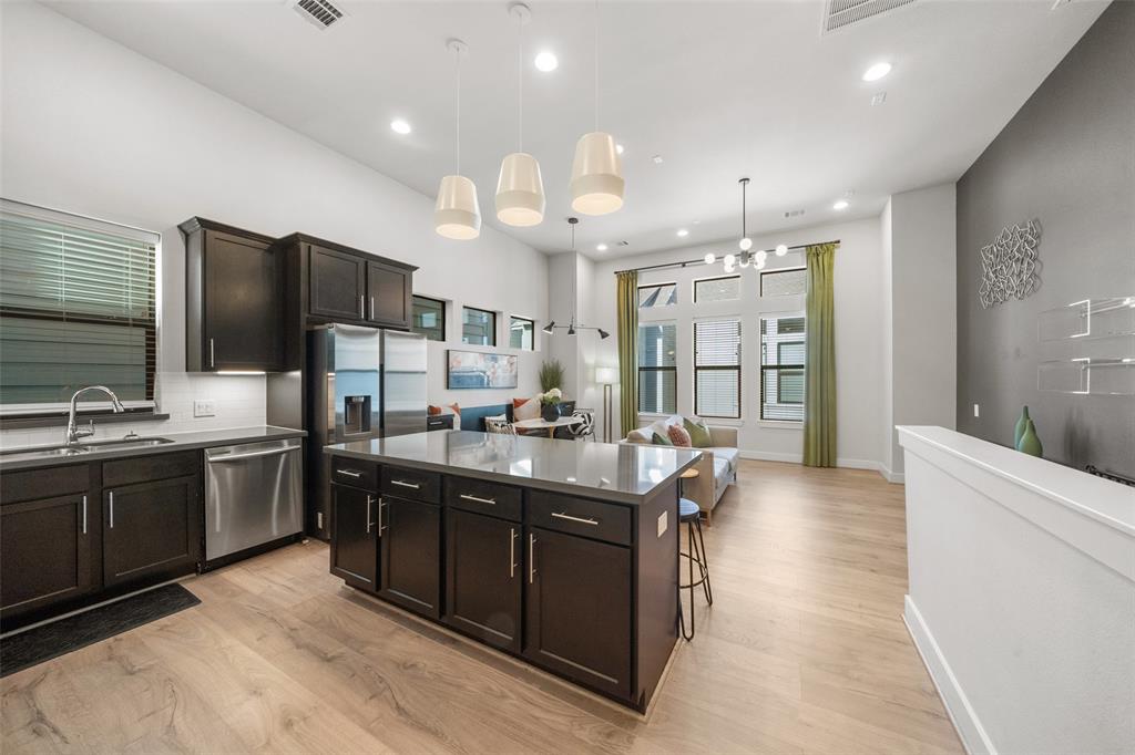 a kitchen with stainless steel appliances granite countertop a sink a stove and a refrigerator