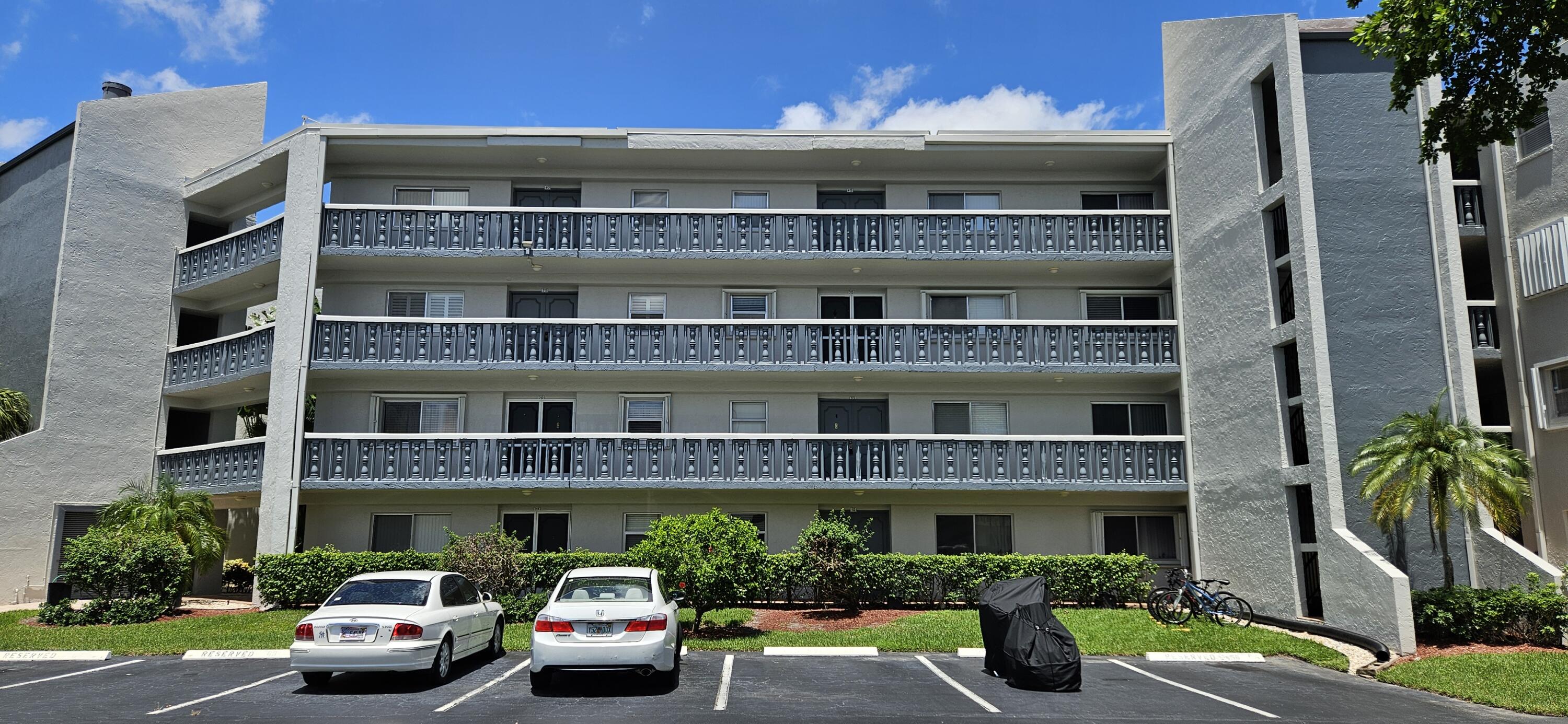 a front view of a building with car parked