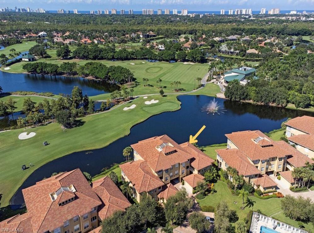 Birds eye view of property with a 18th green golf course and water view