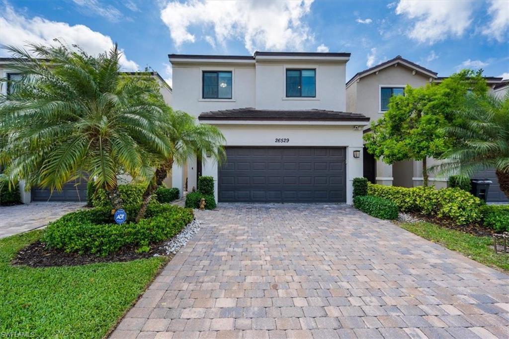 a front view of a house with a yard and a garage