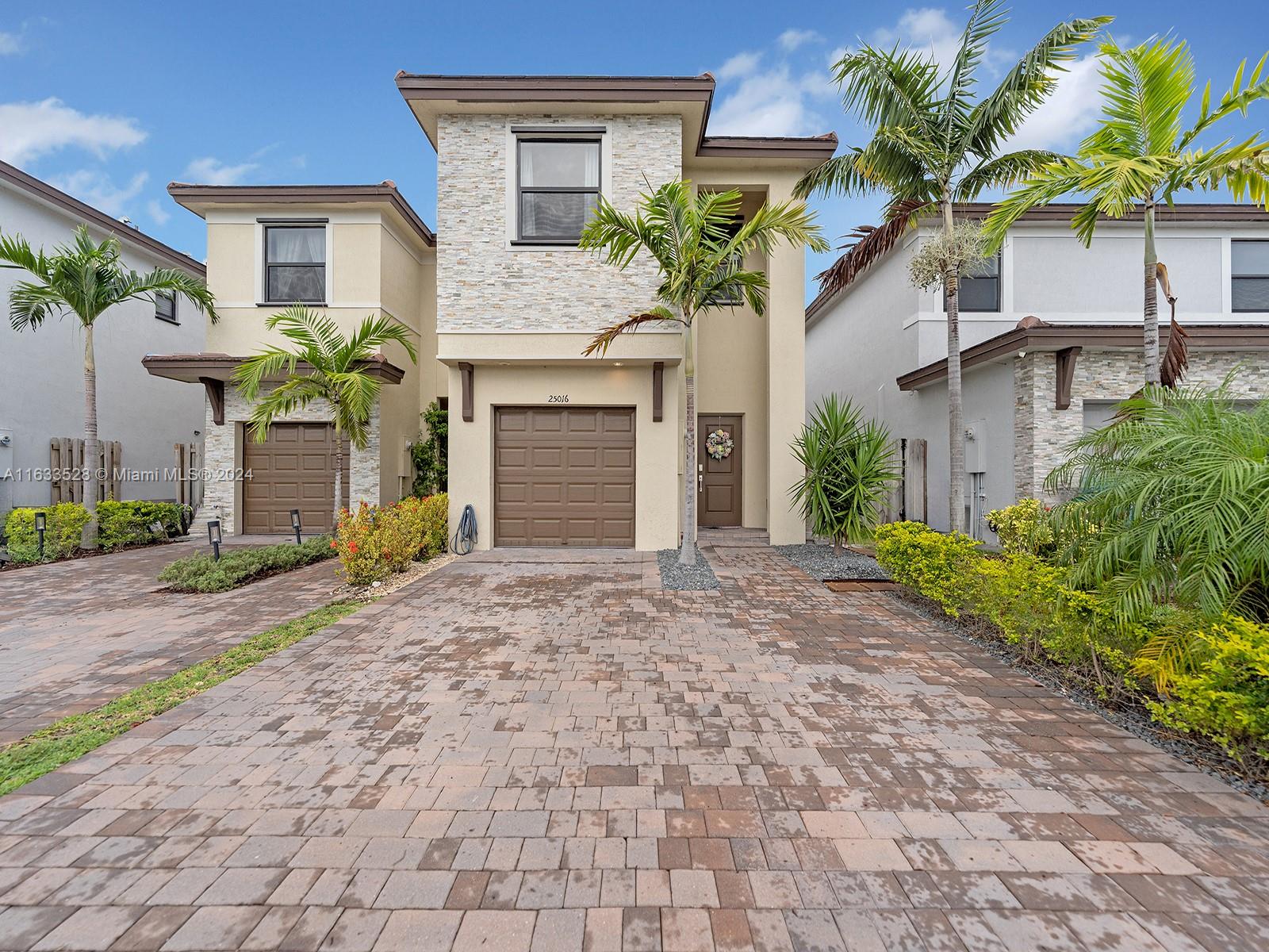 a front view of a house with a yard and a garage