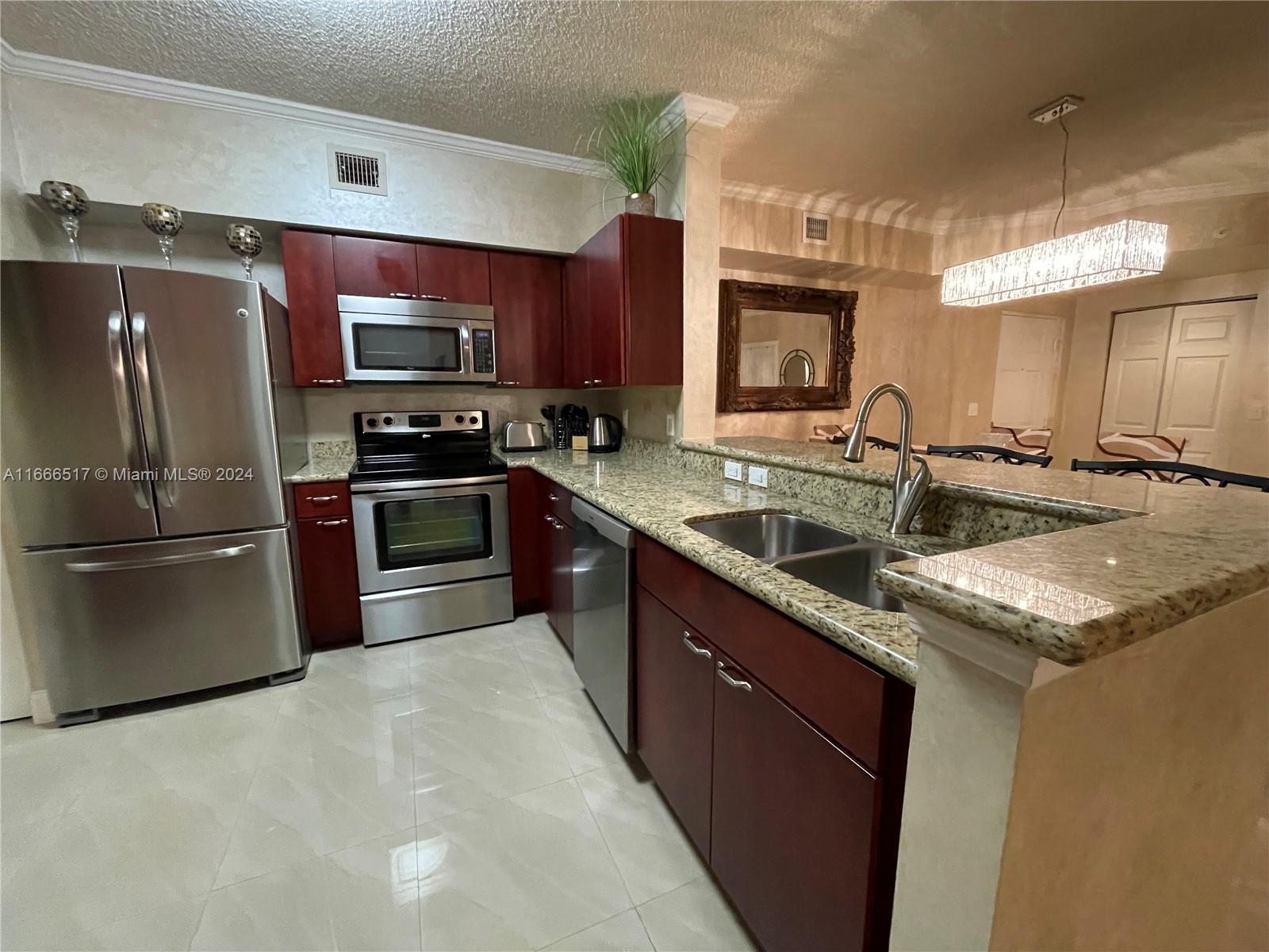 a kitchen with stainless steel appliances granite countertop a sink stove and refrigerator