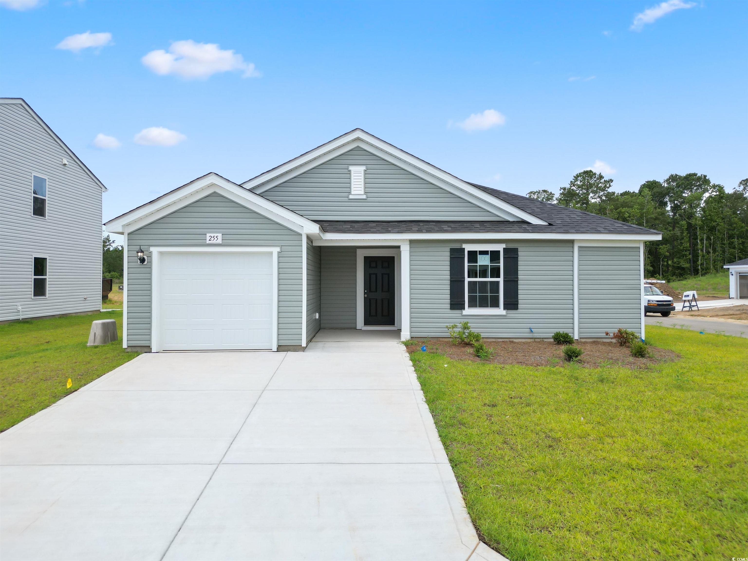 Ranch-style home featuring a garage and a front ya