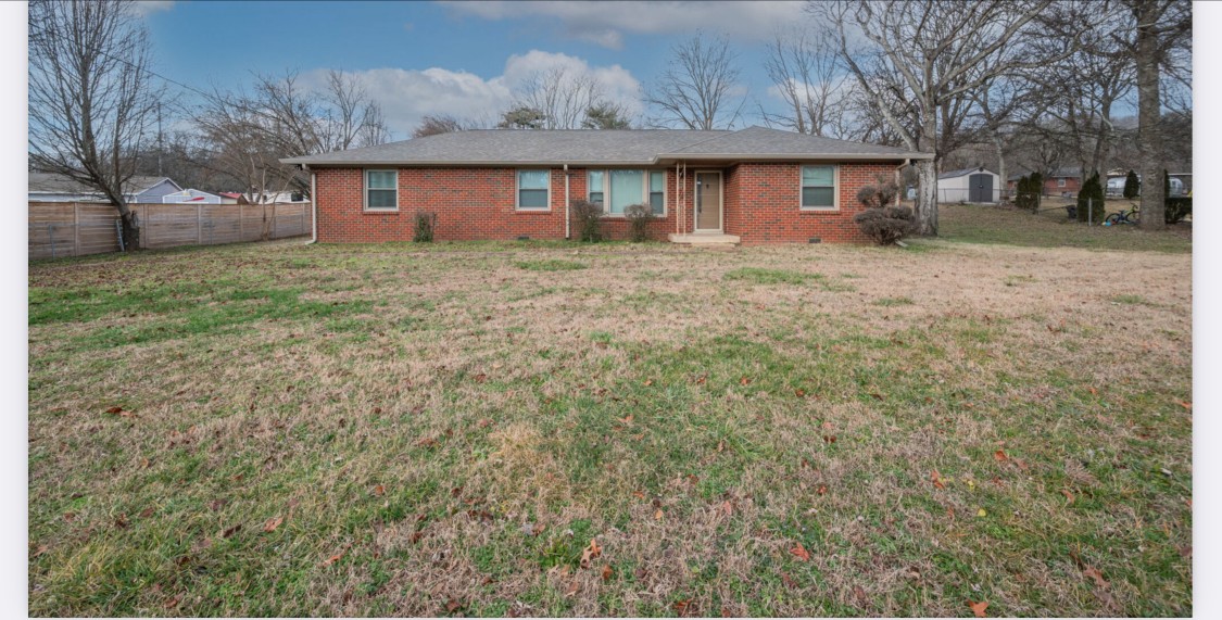 a front view of house with yard and trees around