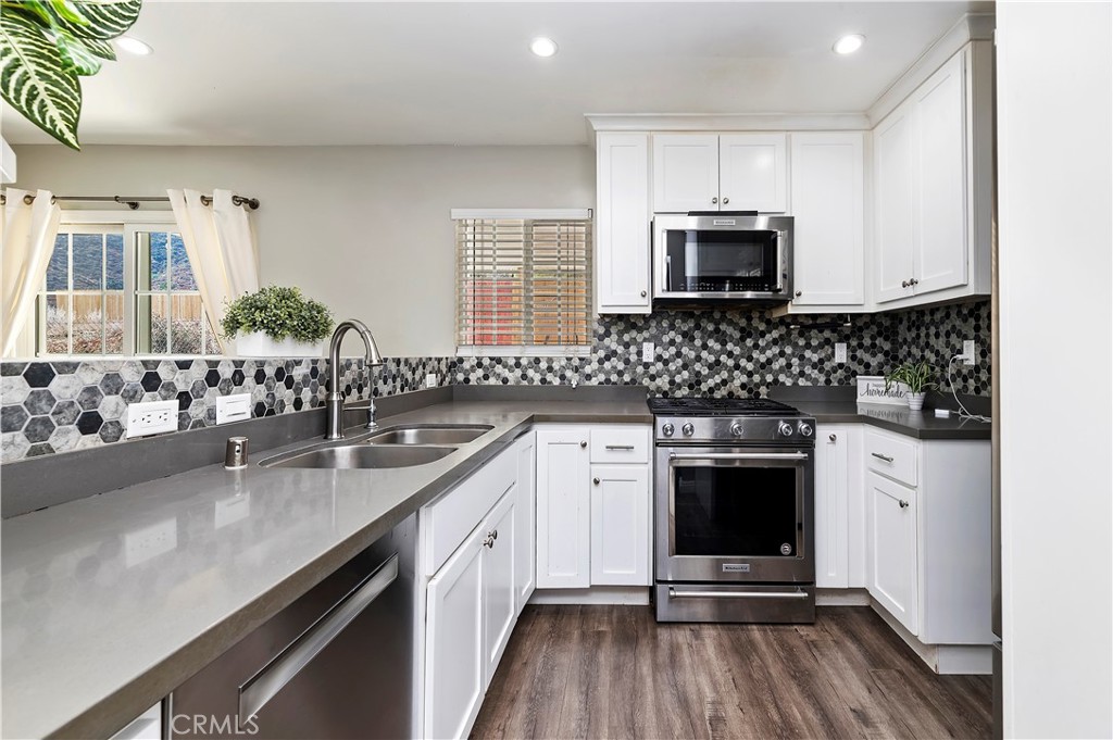 a kitchen with stainless steel appliances granite countertop a sink stove and microwave