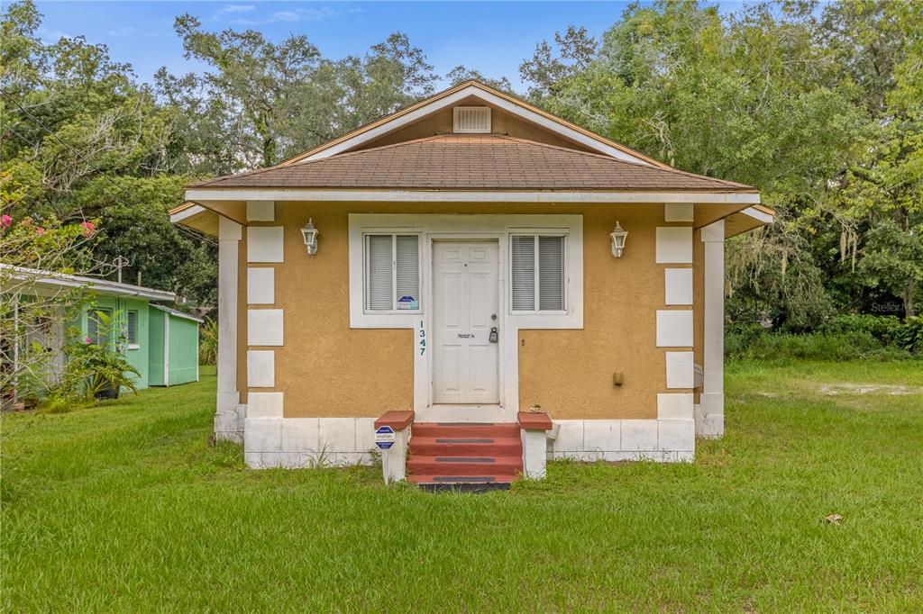 a front view of a house with a garden and yard