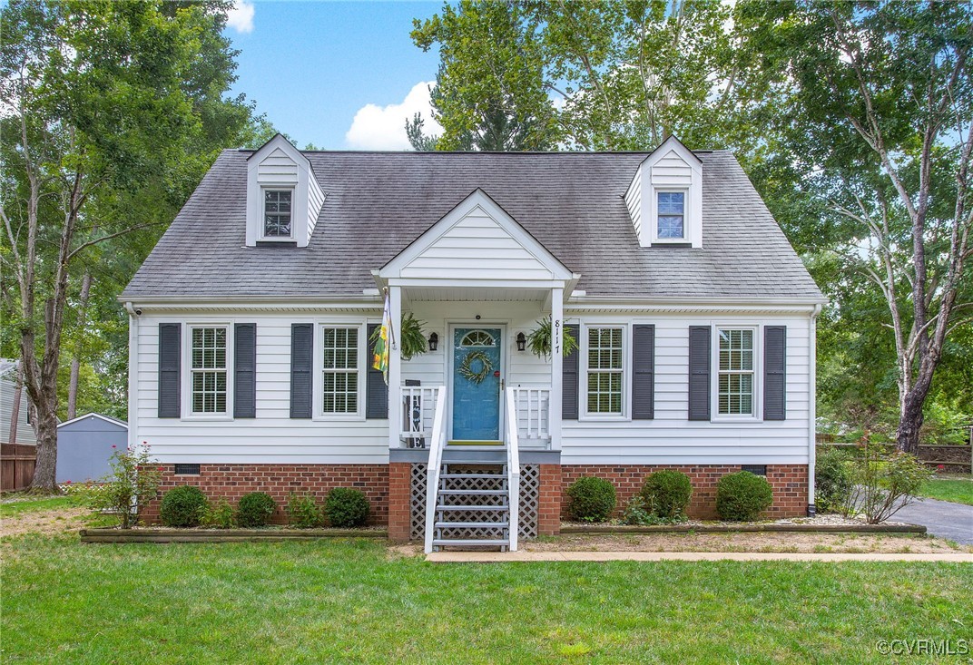 Cape cod house featuring a front yard