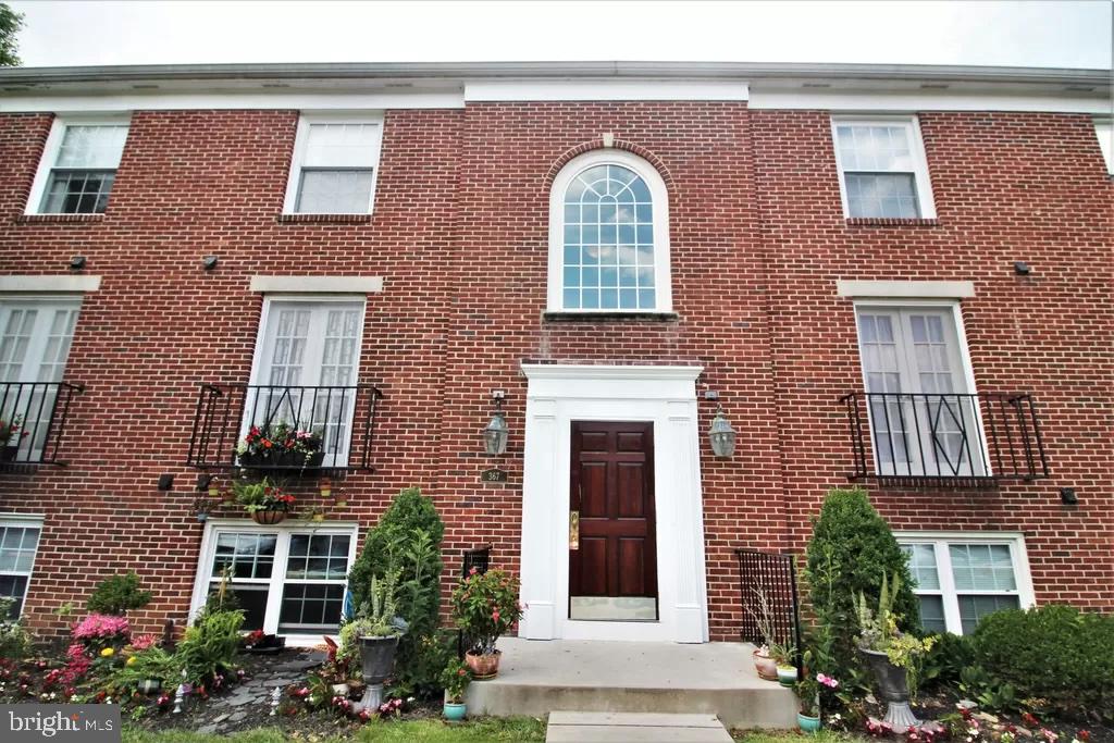 front view of a brick house with a yard