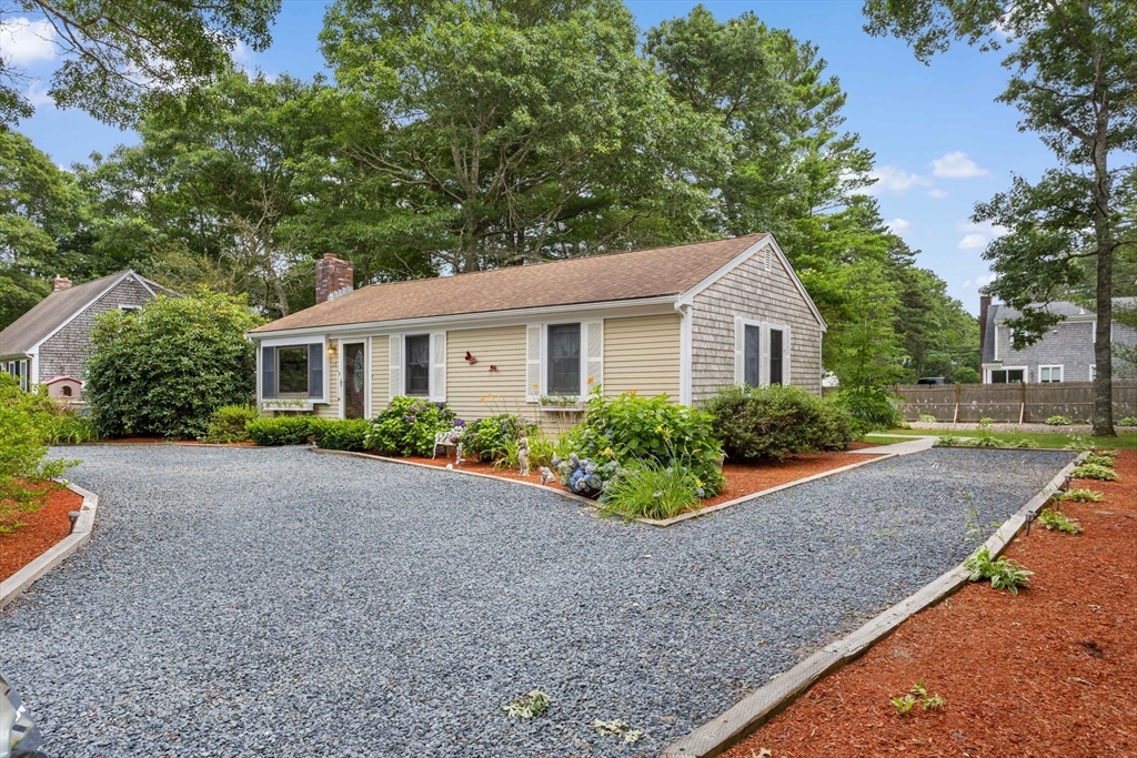 a front view of a house with a yard and potted plants