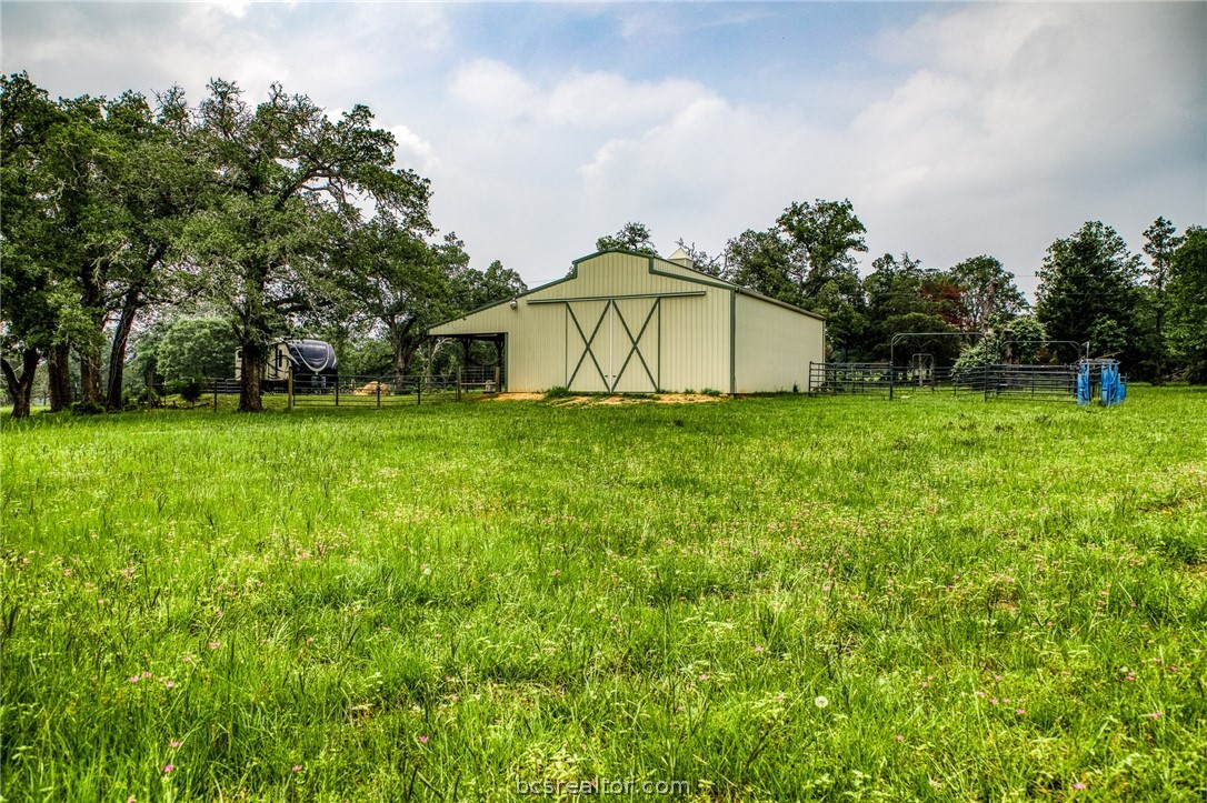 a white house with a big yard and large trees