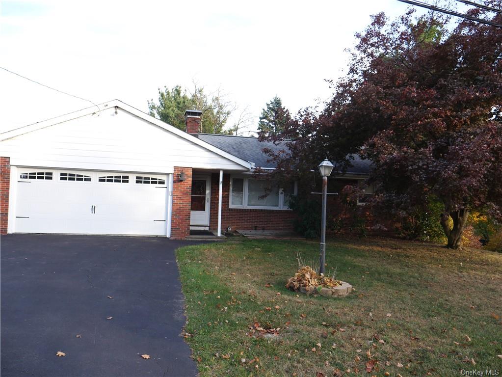 View of front of property featuring a front yard and a garage