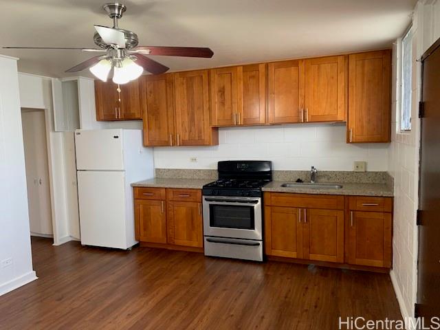 a kitchen with granite countertop wooden floors a sink stainless steel appliances and cabinets