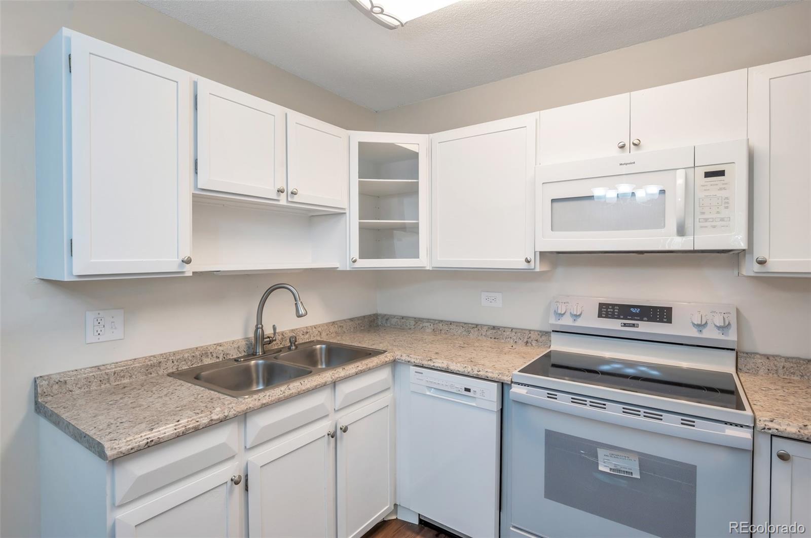 a kitchen with stainless steel appliances granite countertop a sink a stove and cabinets