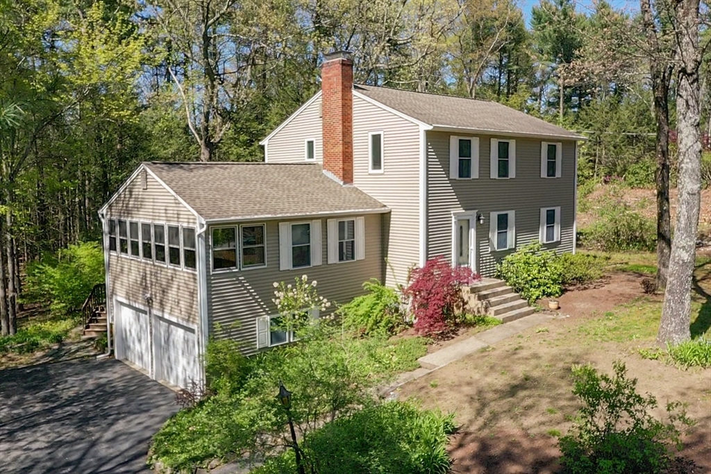 a view of a house with a yard and potted plants