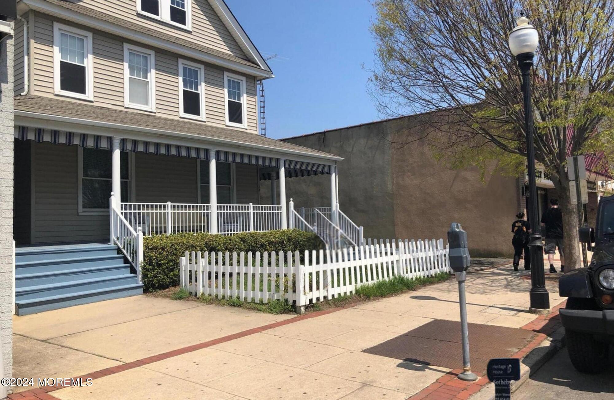 a view of a house with a floor to ceiling window and wooden fence