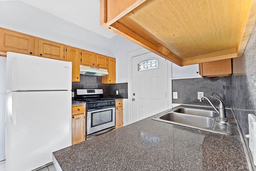 a kitchen with stainless steel appliances granite countertop a sink stove and refrigerator