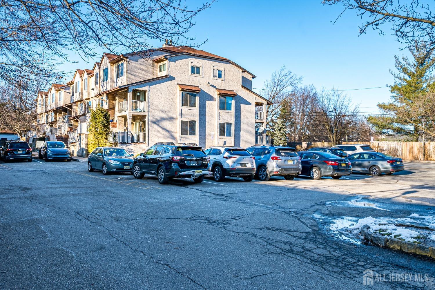 a front view of a building with cars parked