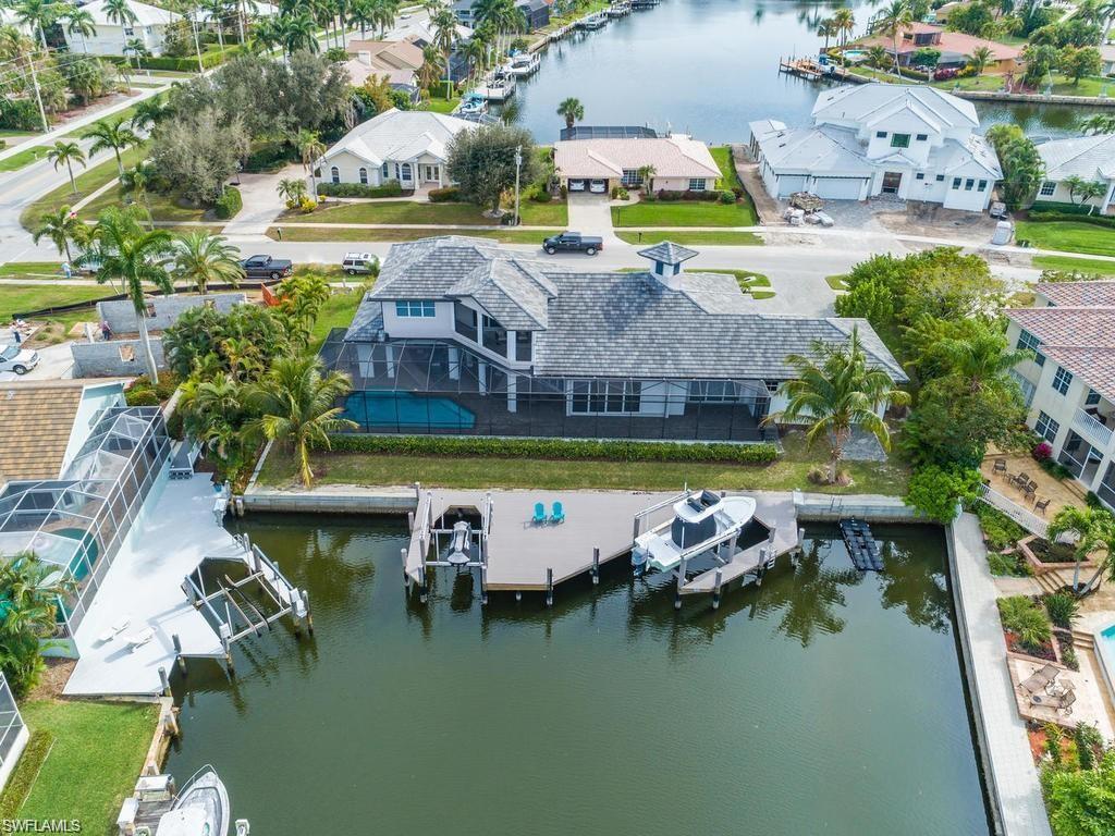 an aerial view of a house with swimming pool a yard and lake view