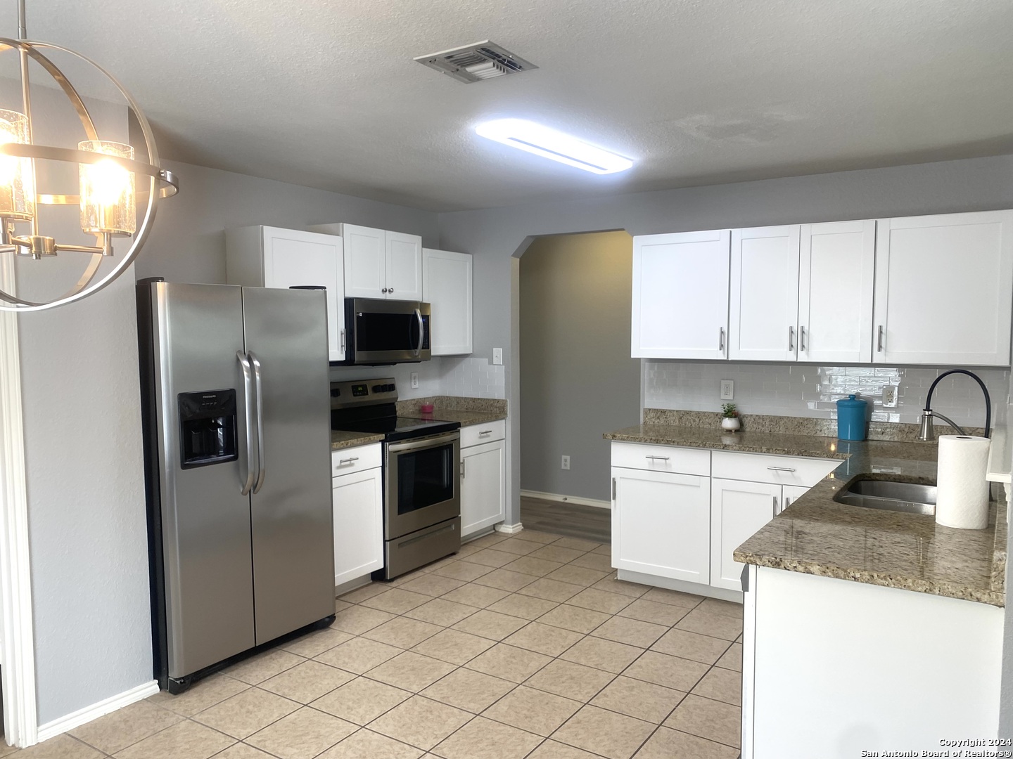 a kitchen with stainless steel appliances granite countertop a refrigerator sink and stove