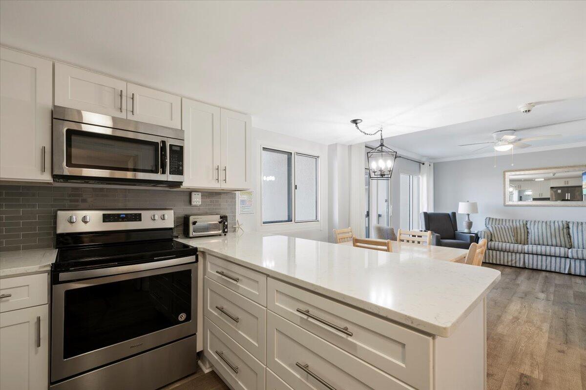 a kitchen with kitchen island a stove microwave and sink