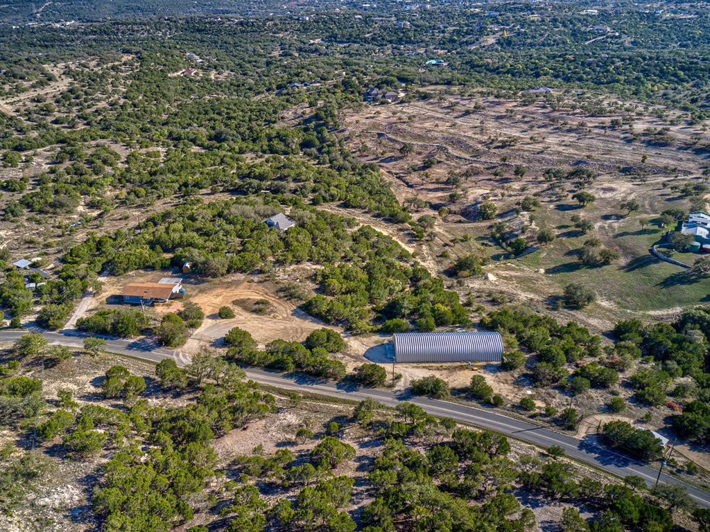 an aerial view of a house with a yard and large trees