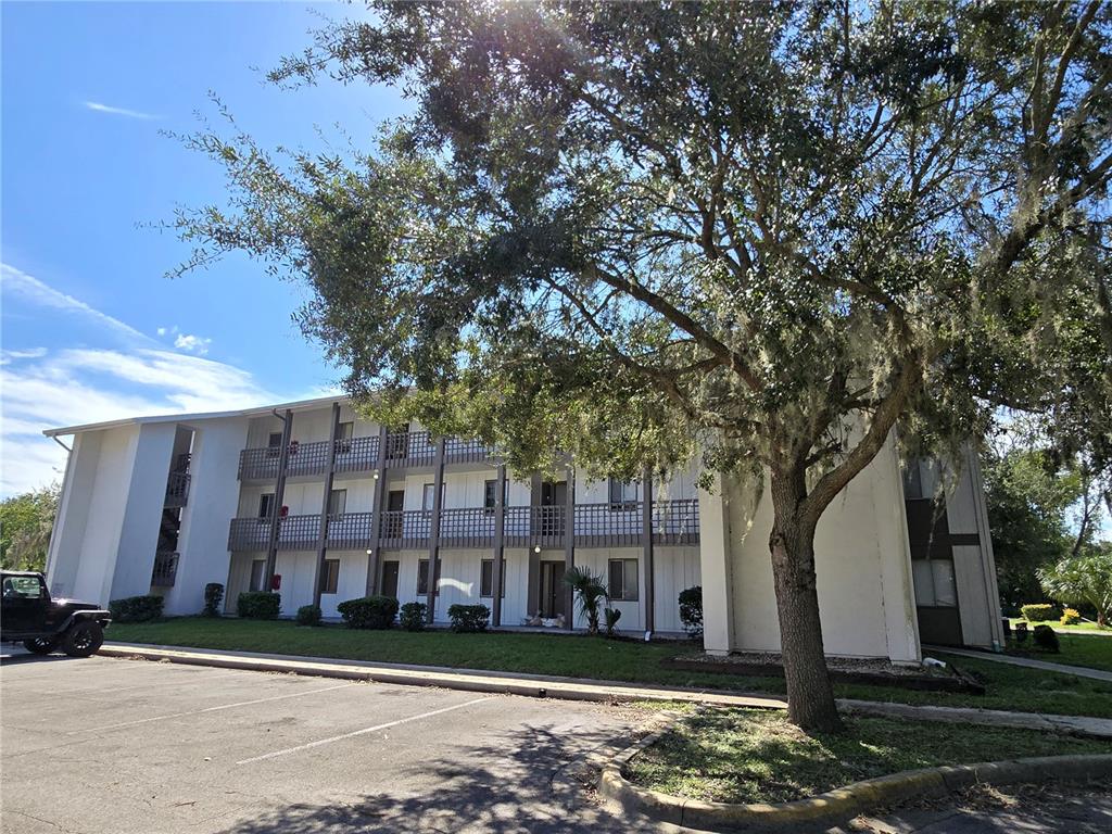 a front view of a building with large trees