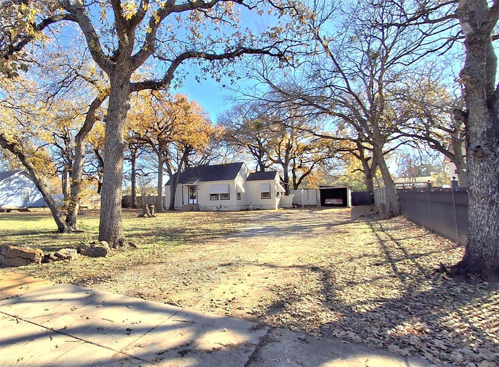 a view of a house with snow yard and trees