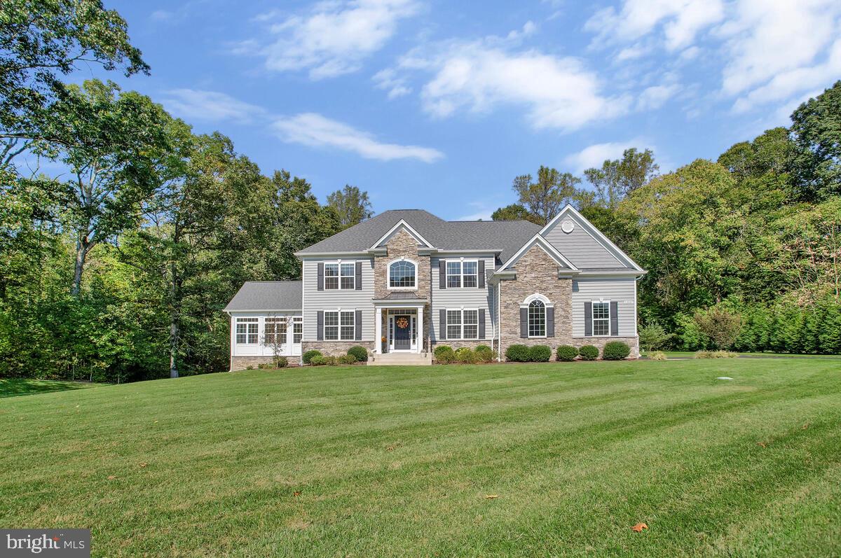 a view of a house with a big yard and large trees