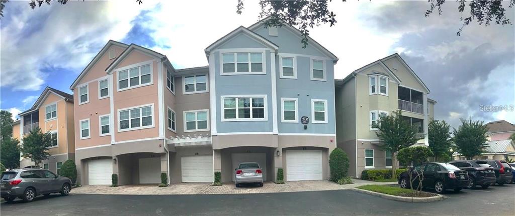 a view of multiple houses with cars parked in front of house