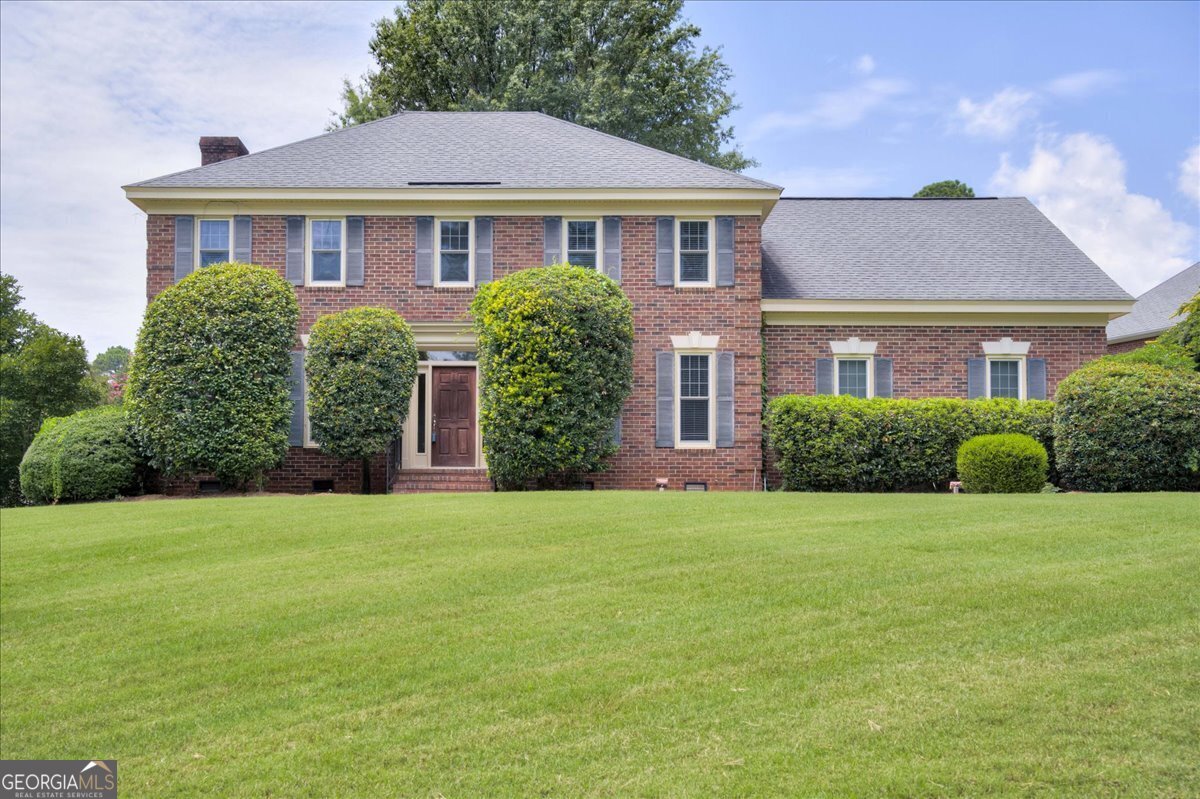 a front view of a house with a garden