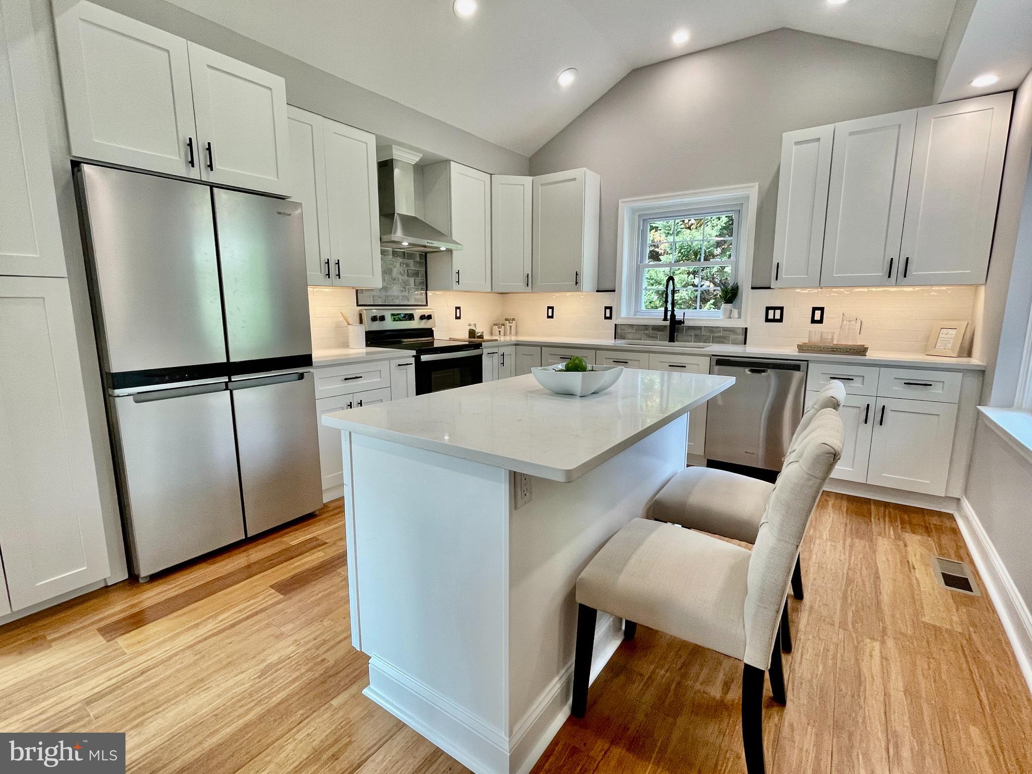 a kitchen with white cabinets and stainless steel appliances