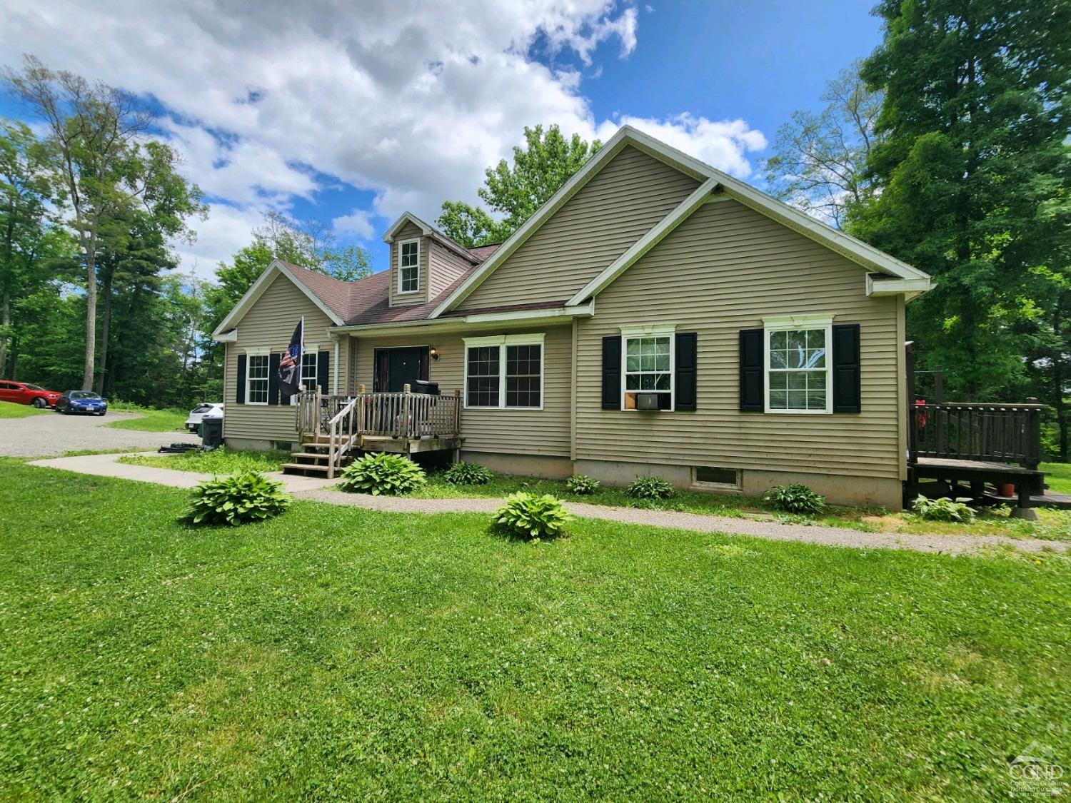 a front view of house with yard and green space