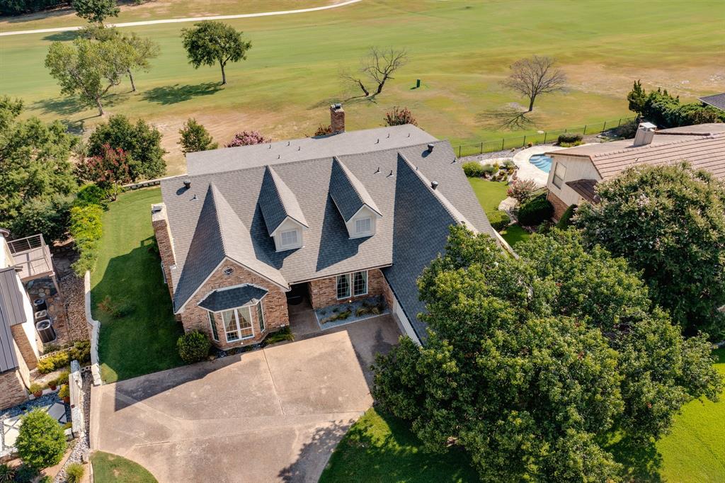 an aerial view of a house with a yard and lake view