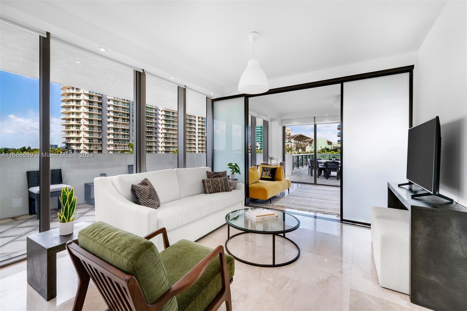 a living room with furniture and floor to ceiling window