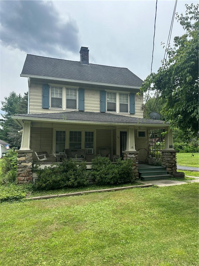 View of front of house featuring covered porch and a front lawn